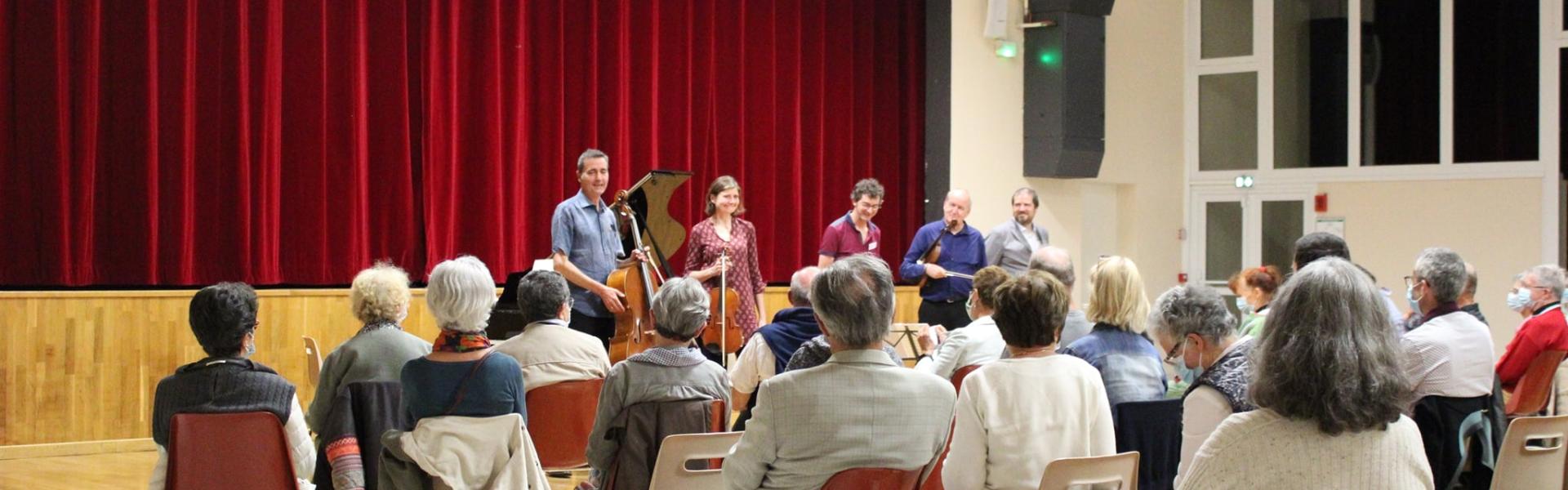 Du public applaudit des artistes dans la salle de Cissé 