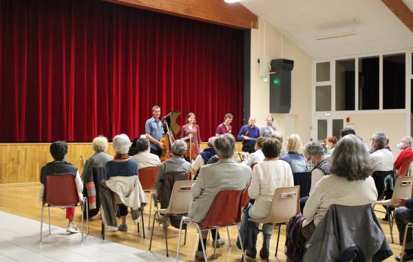 Du public applaudit des artistes dans la salle de Cissé 