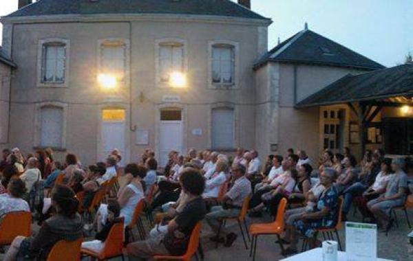 Une photo en fin de journée de la cour de la Mairie de Frozes. Un public très nombreux écoute les musiciens.