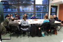 Une assemblée générale de l'association. Des personnes autour d'une table discutent des projets.